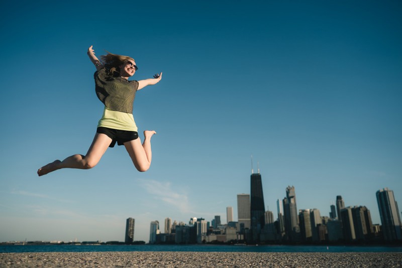 stunning travel portraits: jump shot with city skyline